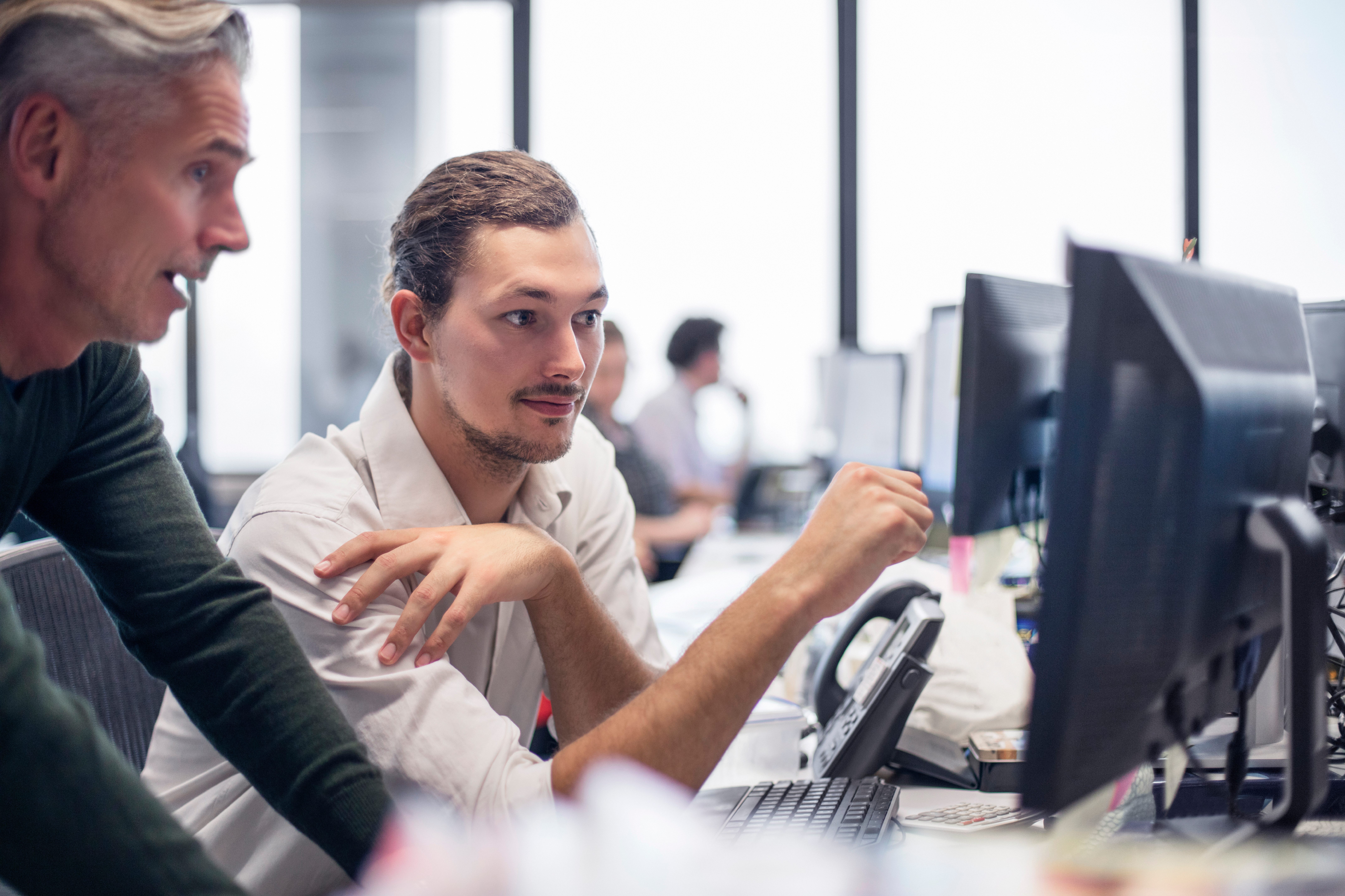 Two colleagues in the office in front of computer