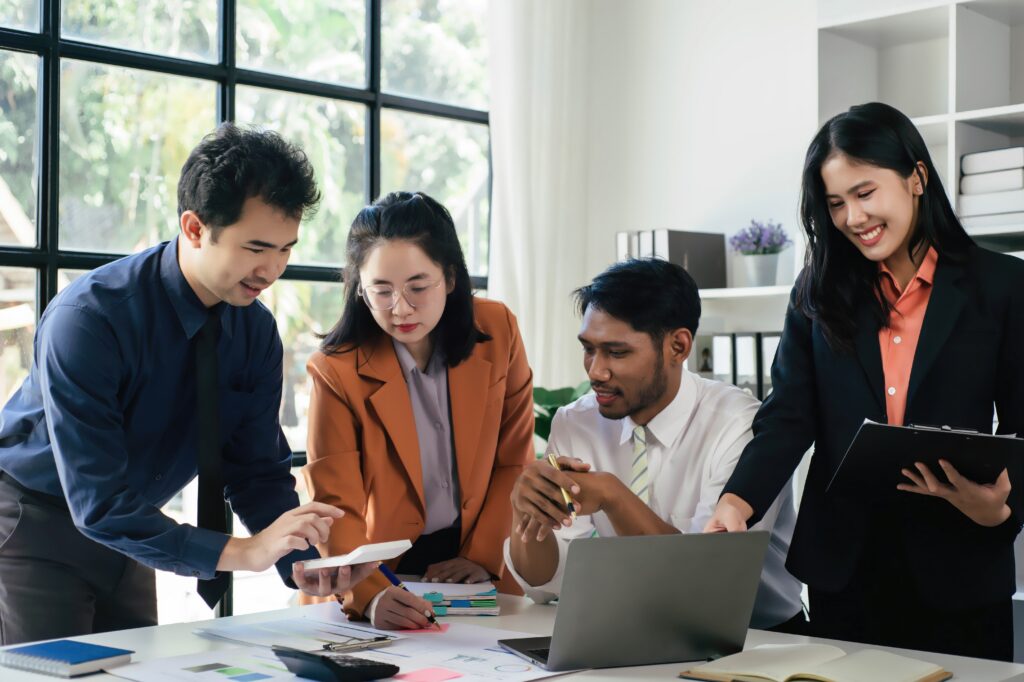オフィスの机の周りに集まって議論する専門家のグループ