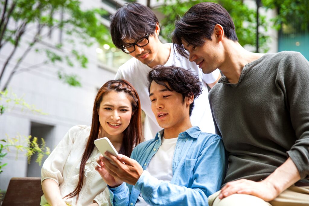 東京の友人が屋外で携帯電話でテキストメッセージを送っています