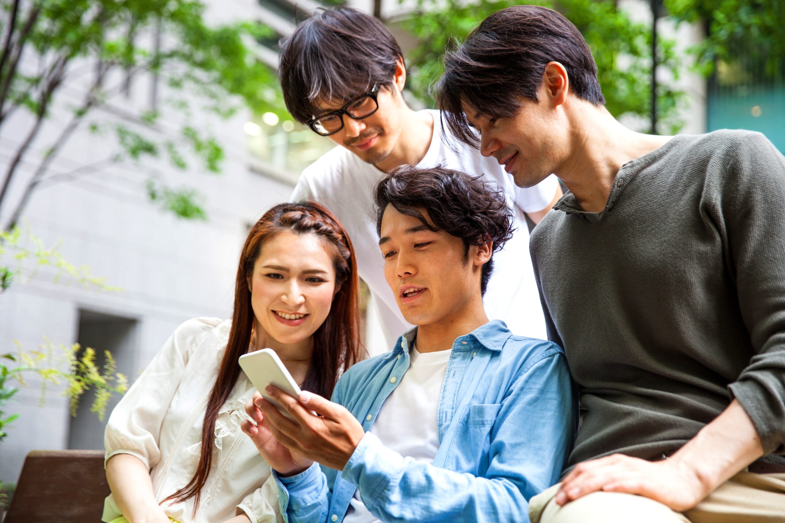 東京の友人が屋外で携帯電話でテキストメッセージを送っています