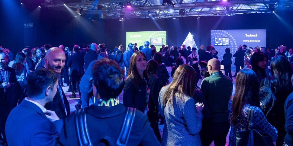 Una sala affollata di partecipanti all'evento intenti a fare networking a Indeed FutureWorks.