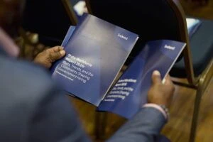 An event attendee holds two reports on public sector hiring from Indeed.