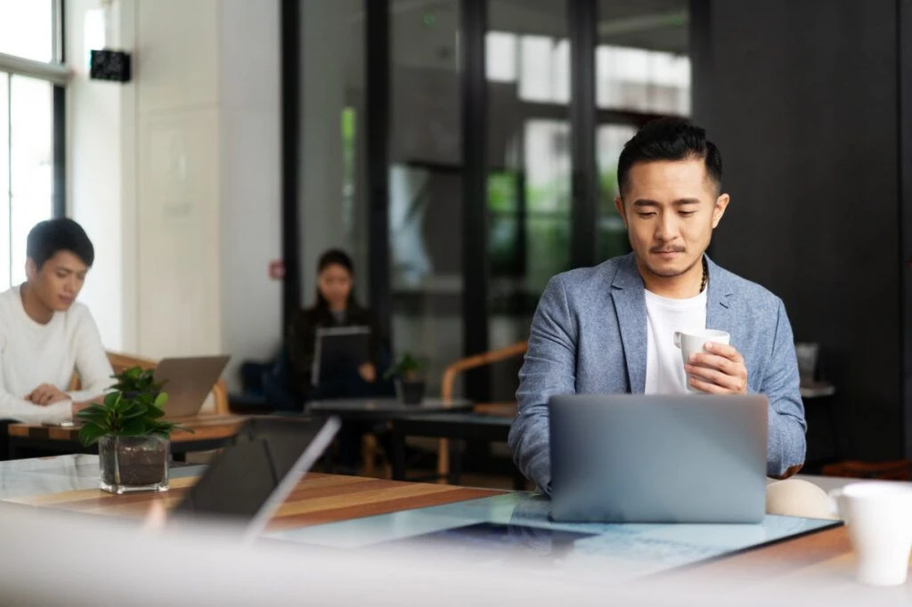 Person arbeitet mobil am Laptop im Coworking Space